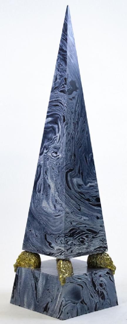 Hollywood Regency Maitland Smith Style Obelisk: Decorative obelisk statue in the style of Maitland Smith. Features a black and gray marbleized finish. Pointed structure resting on four polished brass recumbent lions. Unmarked, attributed to Maitlan