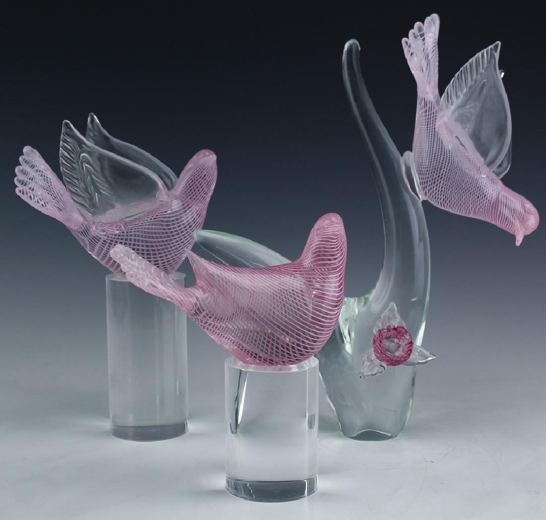Murano Oggetti Italian Art Glass Latticino Doves: Signed Oggetti Murano, Italy studio art glass sculpture and figurines. Features a perched pink latticino dove on a clear branch adorned with a fink flower. Measures 10 1/2" x 12" x 6 1/2". Accompanies