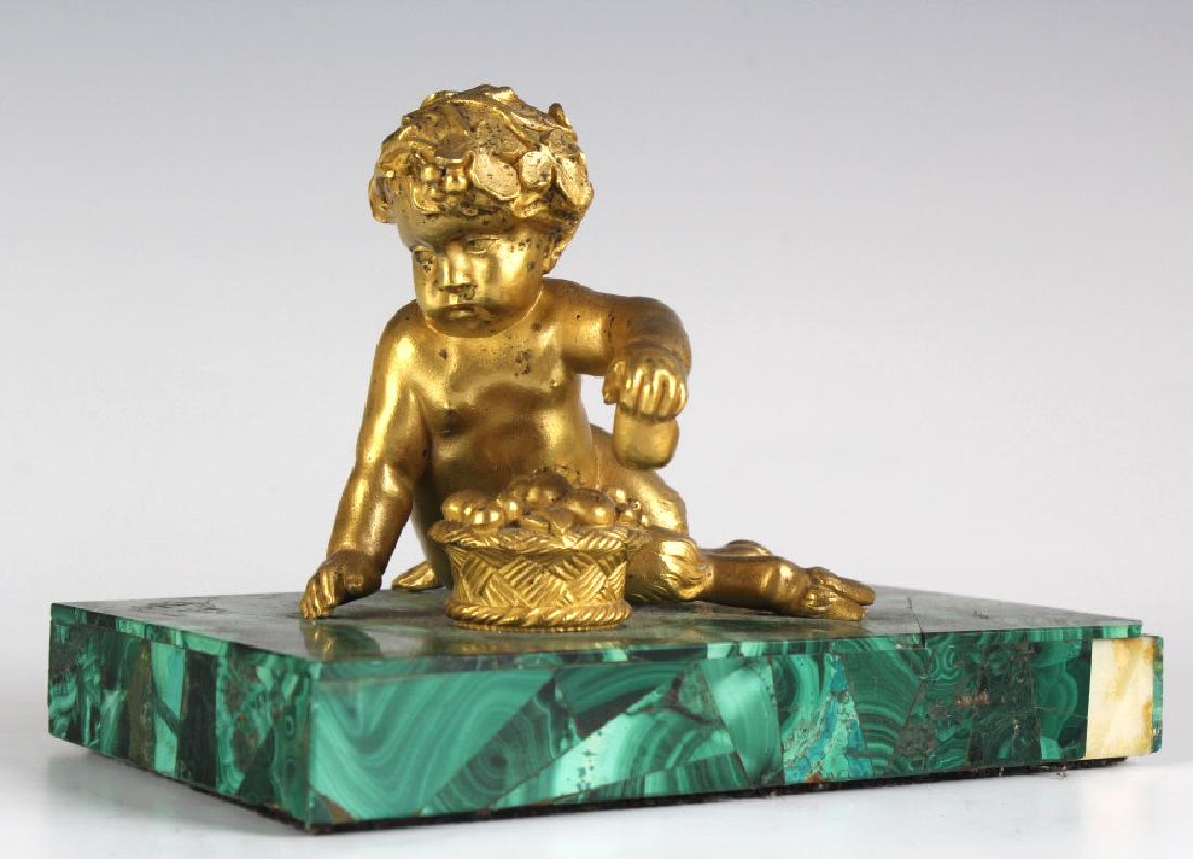 Russian Figural Dore Bronze Sculpture on Malachite: An antique Russian gilt bronze and malachite desk ornament, first half of the 19th century. The veneered malachite base mounted with a finely sculpted dore gold gilt bronze statue of a faun with fruit