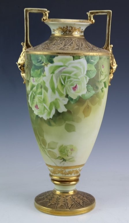 Old Nippon Japanese Porcelain Floral & Gilt Vase: Japanese Nippon vase. Crafted of fine Japanese porcelain decorated with elaborate floral decoration as well as raised gilt decoration. Features a pair of squared handles. Marked in green on base. Meas