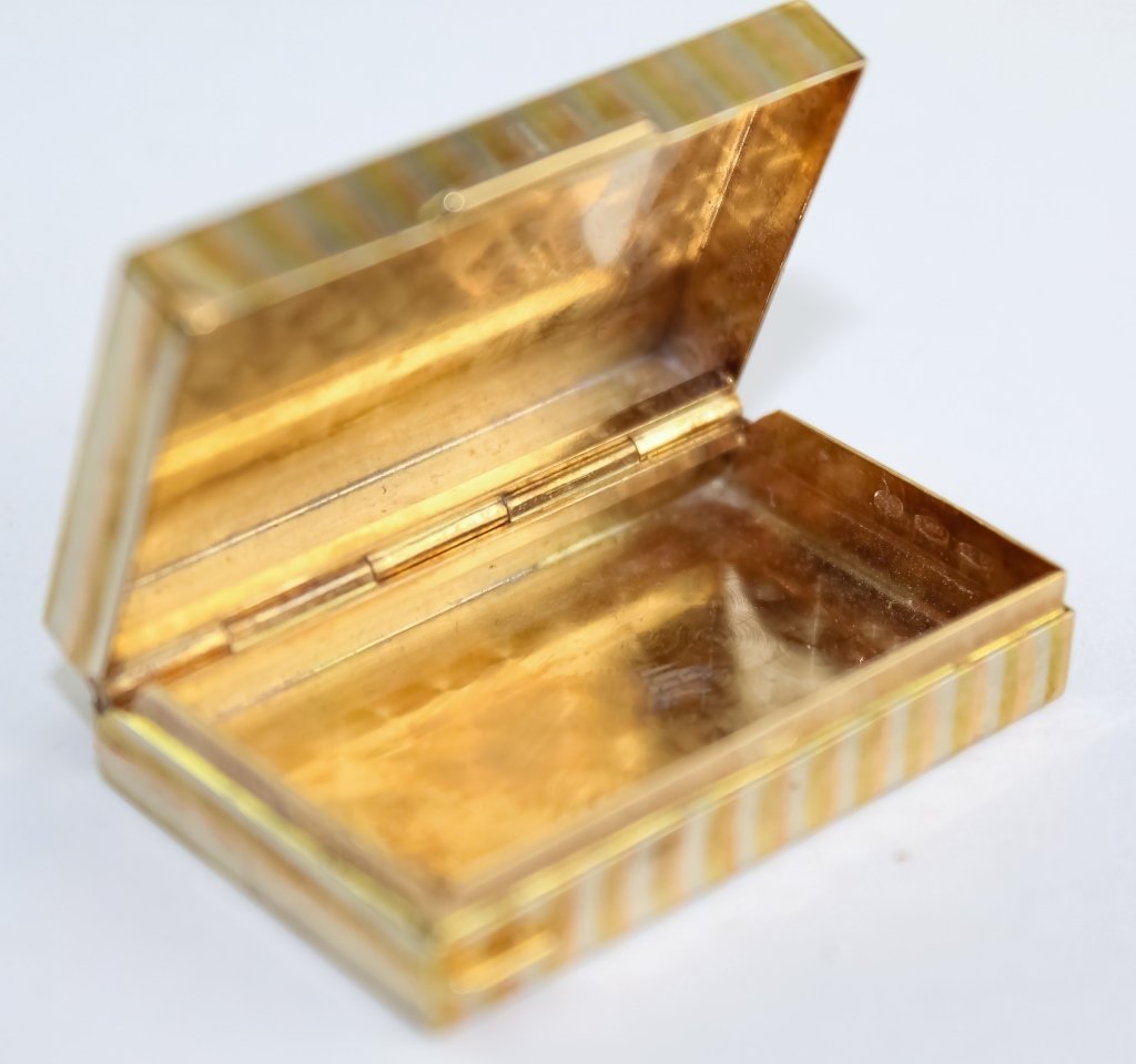 18k Italian Tri-Color Solid Gold Hinged Pill Box: Italian solid 18k gold pill box. Features a textured tri gold design with hinged lid. Marked 750 Italy. Measures 3/8" x 1 1/2" x 1". Weighs 21 grams. Good overall condition with no damage to note. In 