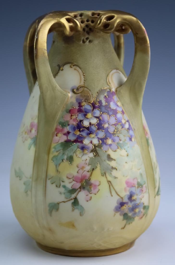 Amphora Nouveau Porcelain Reticulated Handle Vase: Signed Amphora art pottery vase. Features a tear drop form with reticulated four handled decoration at the top. Further embellished with painted floral decoration and raised gilt beading. Measures 7" 