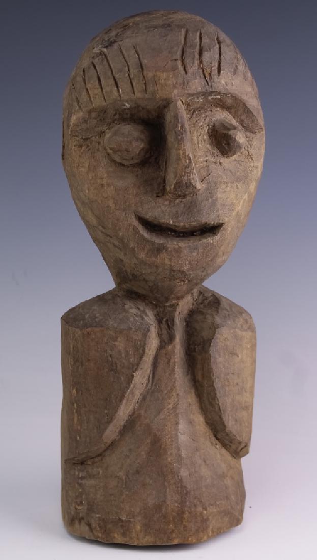 Folk Art Carved Wood Smiling Face Man Sculpture: Hand carved from wood with a brown stain finish. Statue depicts the bust of a smiling man with exaggerated features. Unsigned mystery artist. Measures 14" x 5 1/2" Good condition with mild surface wea