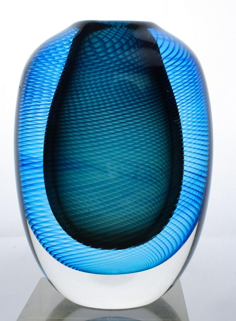 Robinson Scott Studio Art Glass Blue Spiral Vase: Studio art glass vase by Robinson Scott. Features an ovular form with a tight blue spiral cased in clear glass. Measures 7" x 5" x 2 1/2". Signed on base. Good overall condition with minor wear. In ho