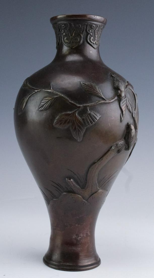 Japanese Meiji Period Bird on Branch Bronze Vase: Crafted of cast bronze with a deep brown patina. High relief bird on branch motif. Opening with geometric stylized floral border. Measures 9" x 4 1/2" Good condition with old repair to bottom. Hill Au