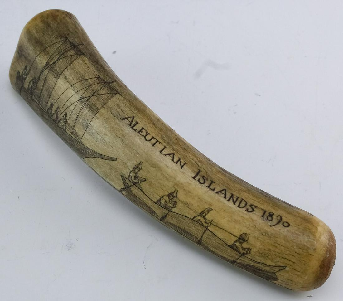 Antique Alaskan Scrimshaw Figural Hand Carved Bone: Antique carved scrimshaw bone. Depicts a pair of boats with men in them and reads Aleutian Islands 1890. Measures 2" x 7 1/2" long. Good overall condition with no damage to note. Hill Auction Gallery 