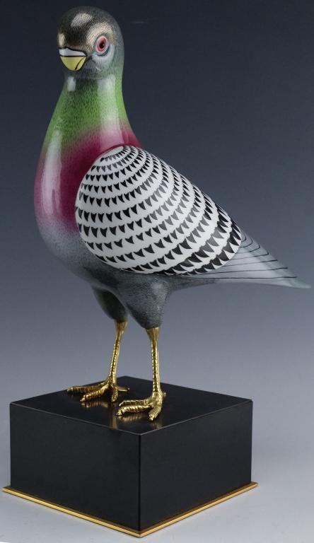 Mangani Oggetti Enameled Porcelain Bird Figurine: Oggetti porcelain bird. Features the colorful rendition of a dove on a black base. Unsigned but attributed to Oggetti. Measures 13" x 8" x 5". Good overall condition with chip to tail. In house, Hill