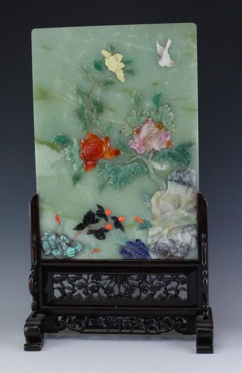Chinese Fine Multi Stone Inlay Jade Table Screen: Large Chinese jade table screen. Features a large green jade panel with coral, lapis, carnelian, turquoise and others. Panel measures 16" x 11". Sits on a reticulated carved wood stand. Measures 22" x