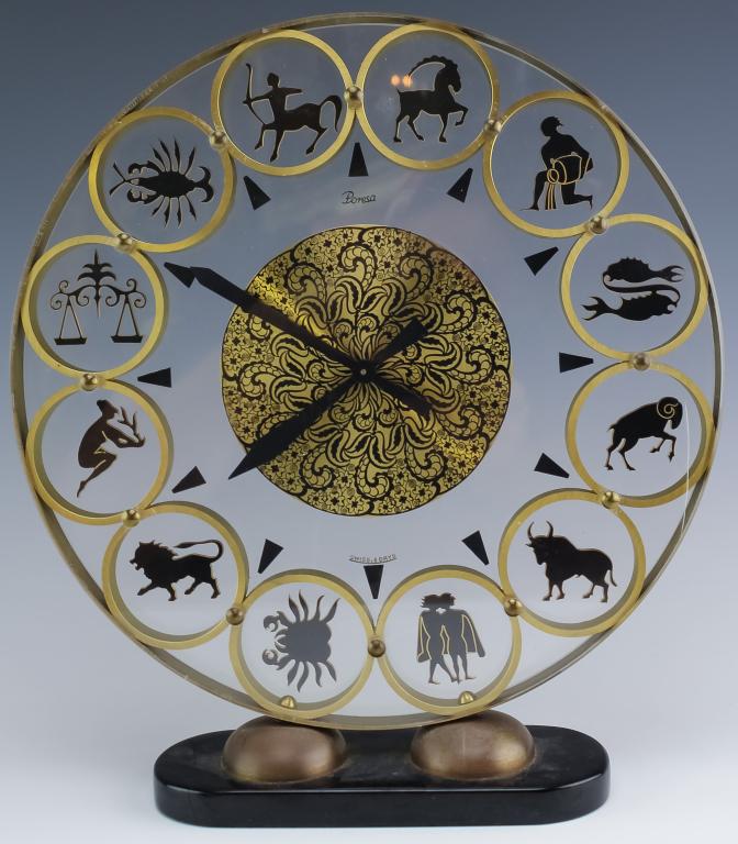 Poresa Swiss Mid Century Zodiac Mantle Desk Clock: Vintage mid century modern mantle clock by Poresa. Features the twelve signs of the Zodiac motif. Crafted in brushed finish brass with black accents sandwiched between lucite. Mechanical wind 8-day Sw