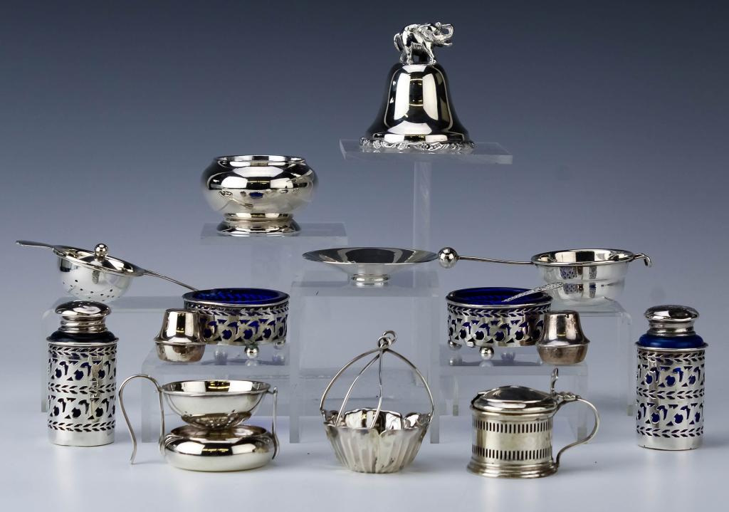 Lot Sterling Silver Salt Cellars Tea Strainer Bell: Collection of thirteen (13) sterling silver items. Included in this lot is the following: 3 glass lined salt cellars, 1 sterling salt cellar, 2 pairs of salt shakers, 4 tea strainers, one elephant for