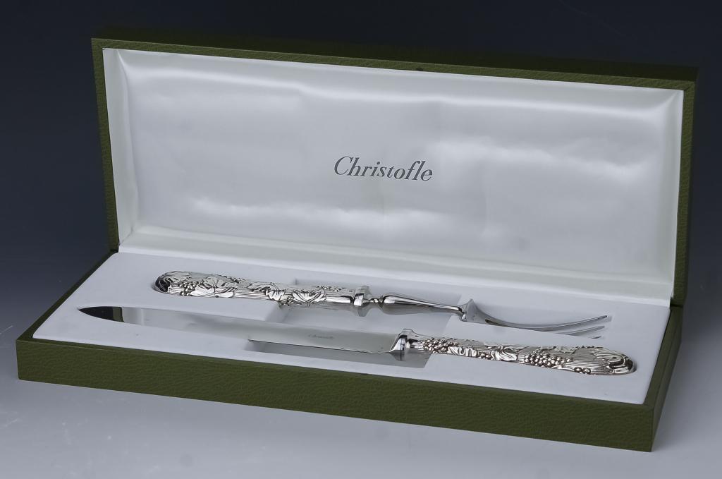 Christofle French Silverplate Vinea Carving Set: Christofle France carving knife and fork. Features the Vinea pattern with raised grape leaf and grape motif. Blade measures 7 1/2", and 13" in total, fork measures 11". Marked Christofle. Comes housed
