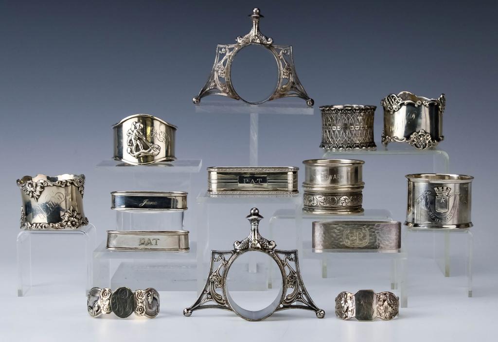 13 Sterling & 2 Silver Plate Antique Napkin Rings: Collection of sterling silver and silver plated napkin rings. Comes with a variety of different rings from simple to elaborate. The pair of standing rings are silver plated. Sterling weight is 285 gra