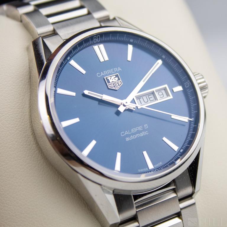 Tag Heuer Carrera Calibre 5 Mens Blue Date Watch: Tag Heuer automatic men's Swiss wristwatch. Features an automatic, 26 jewel, movement housed in a stainless steel brushed and polished case measuring 40mm not including the crown. The blue sunburst di