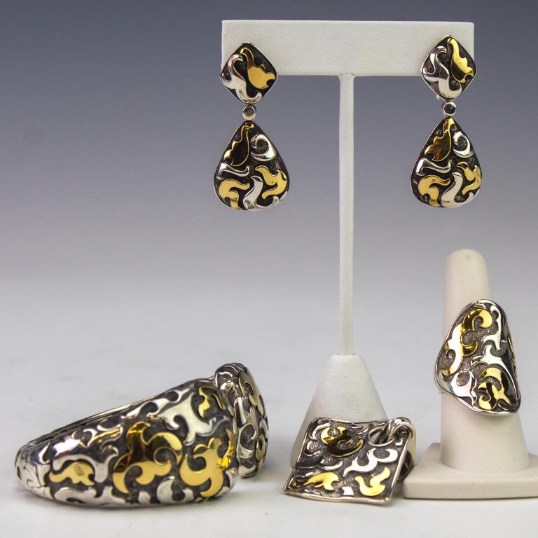 John Hardy Sterling Silver & 22k Gold Dayak Suite: Suite of jewelry by John Hardy. Comes from the Dayak line with polished and matte silver and 22k yellow gold scrolls. Marked JH 925 22k. Pendant: 1 7/8" x 1 1/2". Earrings: 1 3/4 x 3/4". Ring: size 8,