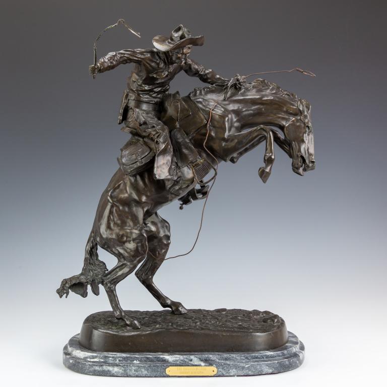 after Remington Bronze Bronco Buster Horse Cowboy: After Frederic Remington (American, 1861-1909) Bronze Southwestern cowboy on horse sculpture, titled "Bronco Buster". Statue on wood base with title on gilt plaque. Artist signature on base of bronze.