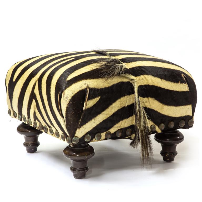 Antique Victorian Era Zebra Hide Covered Footstool: Genuine Zebra hide covered footstool. Rests on turned wood legs. Ottoman approximately 14 in. x 19 in. Good condition with mild surface wear. Hole to hide, missing hairs, wear and staining. Rust and t