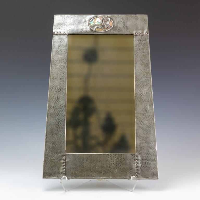 Rare Archibald Knox Hammered Pewter Abalone Mirror: Rare hammered pewter covered mirror attributed to Archibald Knox for Liberty & Co. Hand hammered and riveted pewter with pomegranate flower detail inlaid with abalone shell. Very nice English Arts & C
