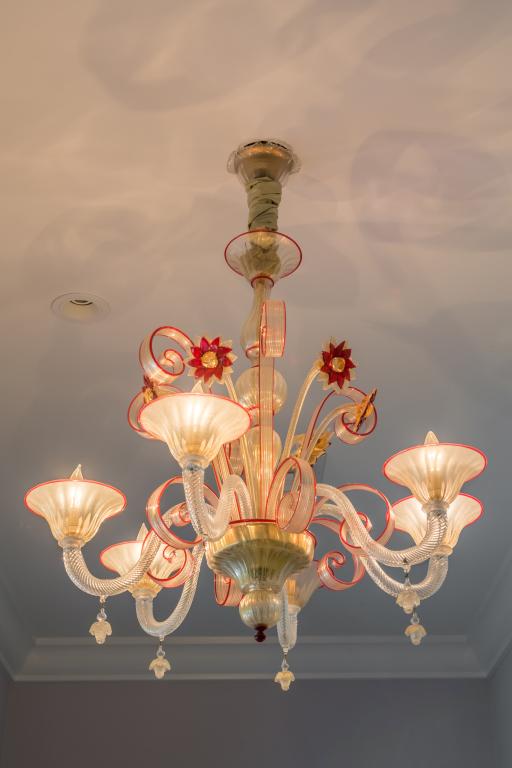 Murano Art Glass Red Flower Six Arm Chandelier: Gorgeous Murano art glass chandelier. Crafted of slightly opalescent clear and red glass with red floral decoration. Six elegant curved arms fitted with lights. Measures approximately 30 in. x 30 in. 