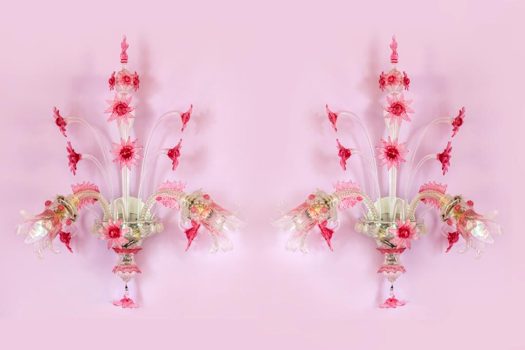 Pair Murano Glass Pink Floral Wall Sconce Lights: Pair of vintage Murano art glass wall sconce lights. Floral design with two lights and pink flowers. Each approximately 26 in. x 22 in. Good condition with mild surface wear. Missing one cluster cap. 