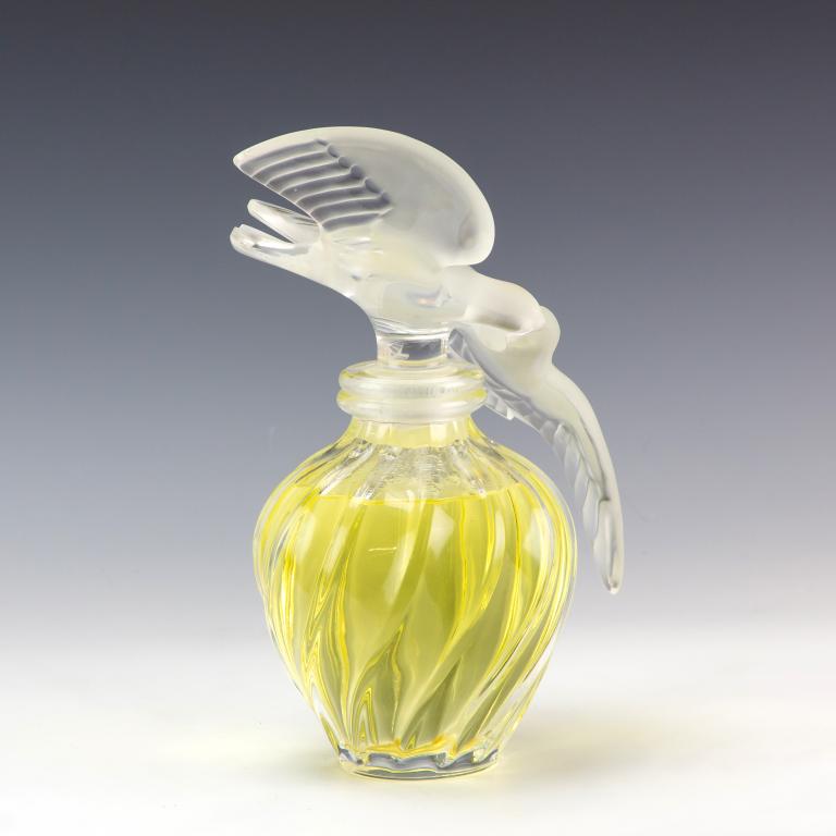 Lalique L air Du Temps Display Bottle And Stand: Lalique "L'air Du Temps" Nina Ricci store scent bottle. Includes four legged clear lucite display stand with mirror top. Bottle: 12 in. x 9 in. x 8 in. Stand: 30 in. x 15 in. x 15 in. Condition is goo