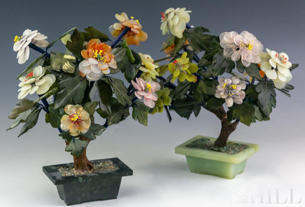 Pair Chinese Export Caved Jade Trees With Flowers: Pair of carved jade and multi stone floral tree. Features jade, rose quartz, agate, and other stones. Each measures 12" x 11" x 7". Good overall condition with wear. Hill Auction Gallery in house USA 