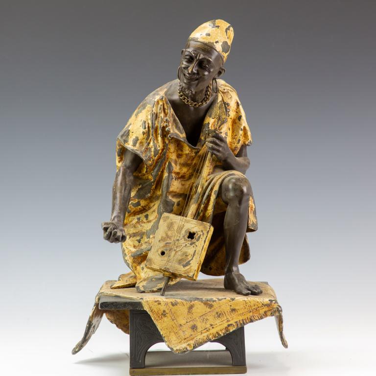 LARGE Bergman Type Orientalist Musician Sculpture: Manner of F. Bergman, White metal Orientalist cold painted figural sculpture. Features the form of a man holding a stringed instrument seated on a rug and fixed to a plinth. Embellished with cold pain