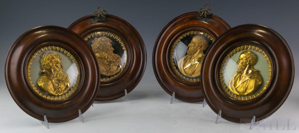 4 Victorian Relief Ormolu Portrait Bust Plaques: Assembled group of four antique English Victorian era relief portrait busts. Crafted of bronze with gold gilt finish. Features bearded gentleman surrounded by a feather style border and set into round
