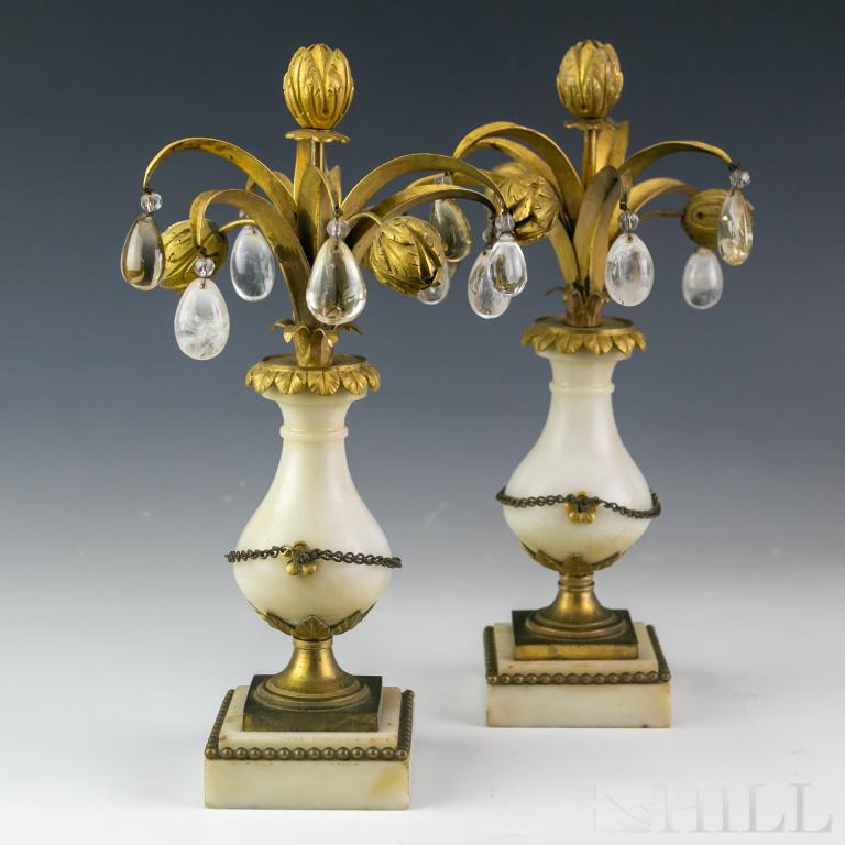 Pair French Dore Bronze Rock Crystal Garnitures: Crafted of alabaster or white marble with gold gilt dore bronze mountings. Urn form with tulip type bronze flowers and leaves. Rock crystal teardrops suspended from tips of leaves. Each approximately 