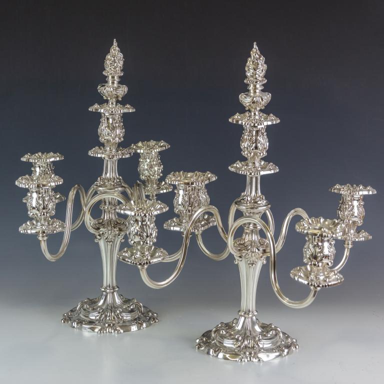 Pair Reed & Barton Silverplated 5 Light Candelabra: Pair of vintage signed Reed & Barton candelabras. Fine quality American silver plate. Features an ornate French inspired design with four arms surrounding a central holder. Comes complete with flame u