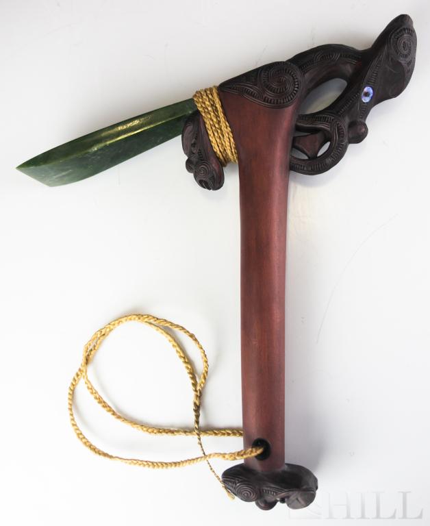 Maori Hand Carved Adze w Greenstone Jade Blade: Toki Pou Tangata or Maori Adze. Hand carved wood with intricate design accented with paua shell highlights. Mounted with New Zealand greenstone jade blade and adorned with natural bindings. Measures 1