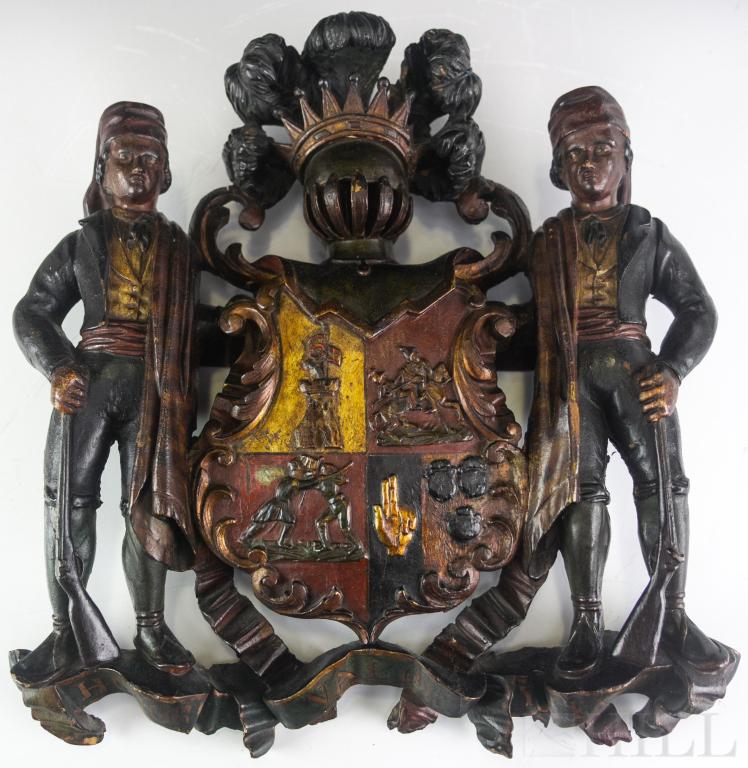 Antique 18c Spanish Carved Wood Coat of Arms: Antique Spanish late 18th to early 19th century armorial crest. Hand carved wood with polychrome and remnants of gold gilt finish. Depicts a coat of arms topped by a knight's helmet and plumes. Flanke