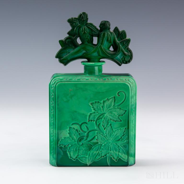 Malachite Glass Perfume Bottle Figural Nude Stop: Malachite glass perfume bottle. Heavily carved vine leaf design with figural nude stopper. Bottle: 7 1/2 in. x 4 1/2 in. x 2 in. Good condition, showing normal age wear. Hill Auction Gallery in house
