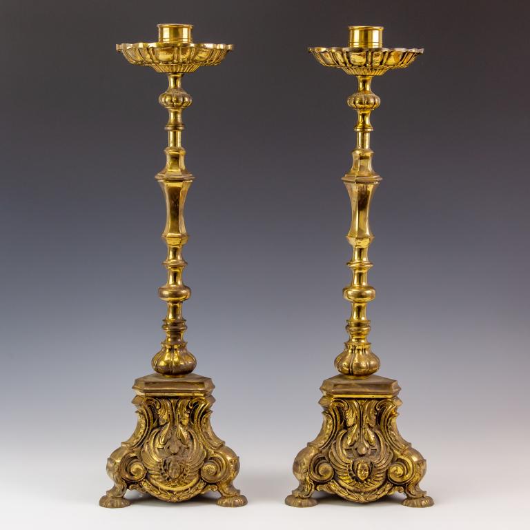 PR Ornate Bronze Angle Rococo Style Candlesticks: Large pair beautiful ornate bronze candlesticks with flowing rococo style scroll. Elegant French style scrolling foliate cartouche, with angle faces. Candlesticks: 24 in. x 7 in. x 6 in. Good conditio