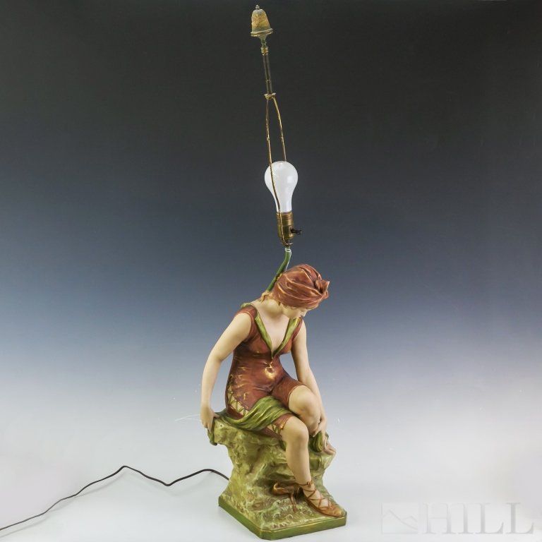 Antique Royal Dux Seated Ballerina Porcelain Lamp: Crafted of fine quality Bohemian porcelain. Features a young ballerina or dancer attending to her foot. Decorated in green red and gold colors. Signed with the Royal Dux pink triangle mark. Figure mea