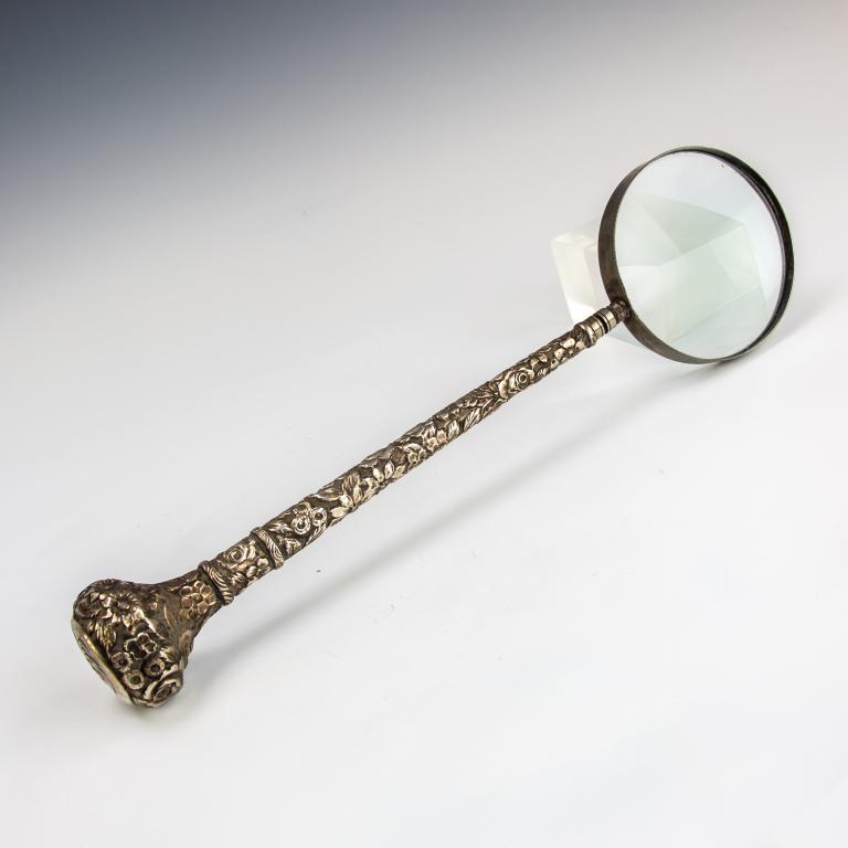 Old Hand Made Sterling Silver Repousse Magnifier: Antique hand made sterling silver repousse magnifying glass. Features a long 11" handle with high relief floral repousse. Glass measures 4" in diameter. Good to fair overall condition with dents and w