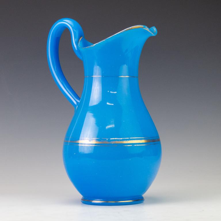 Antique French Blue Opaline Gilt Glass Pitcher: Antique French blue opaline glass pitcher. Comes with large capacity and large handle. Embellished with gold gilt. Measures 12 1/2" x 8 1/2". Good overall condition with minor wear. Hill Auction Galle