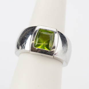 Cartier 18k White Gold Green Peridot Ring Size 7: Guaranteed Authentic Vintage Cartier white gold and Peridot ring. Features a bezel set green Peridot set in a 11.4mm wide white gold band. Weighs 21 grams. Size 7. Signed Cartier 750 53 NW2689.