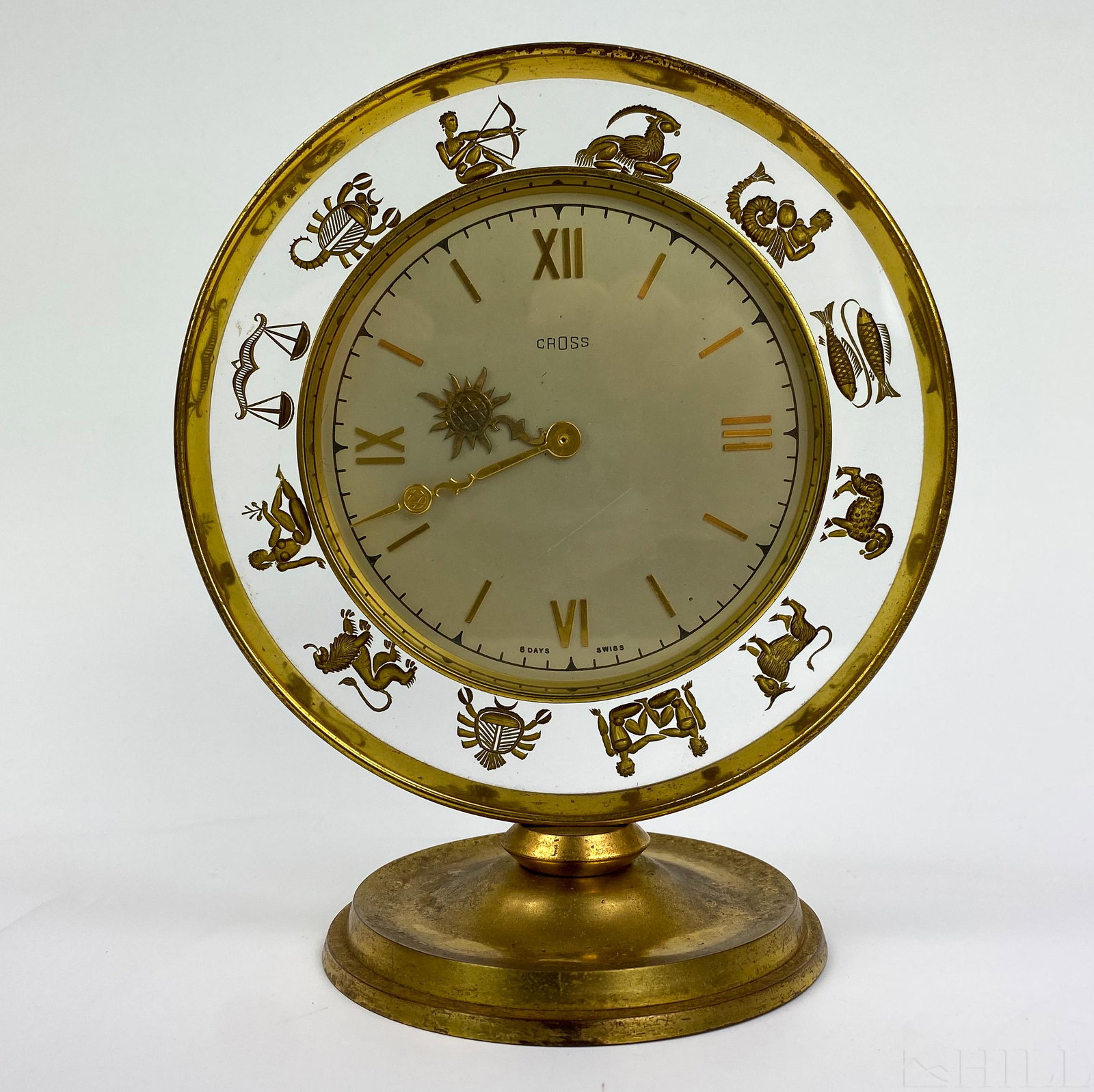 Cross 8 Day Zodiac Astrological Swiss Desk Clock: Rare Zodiac Clock by Cross. Features a sun form hour hand and Roman numeral indicators as well as the signs of the Zodiac in gold gilt intaglio in the outer rim. Signed Cross 8 Days Swiss. Measures 7 