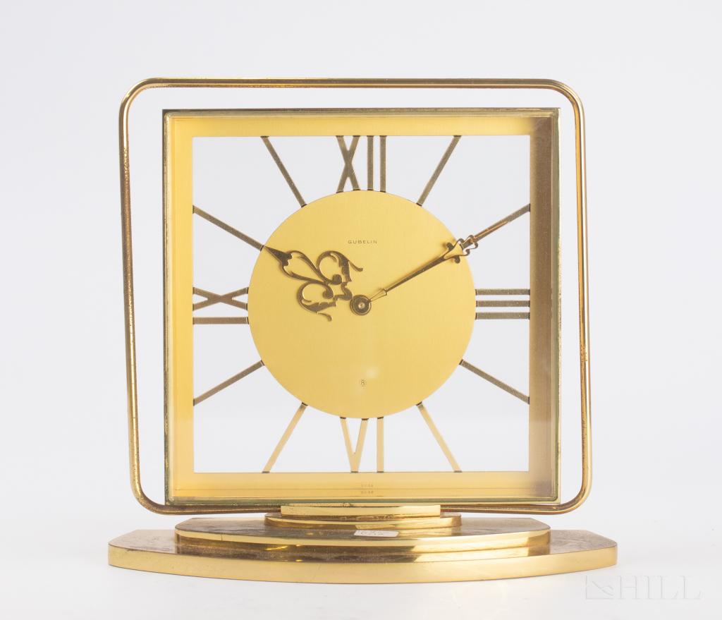 Gubelin Vintage Skeleton Gilt Brass Mantle Clock: Vintage gilt bronze Swiss clock by Gubelin. Features elaborate hands over a frosted gilt dial and polished indicators. Measures 7 1/4 in. x 7 1/4 in. x 2 3/8 in. Good overall condition with surface we