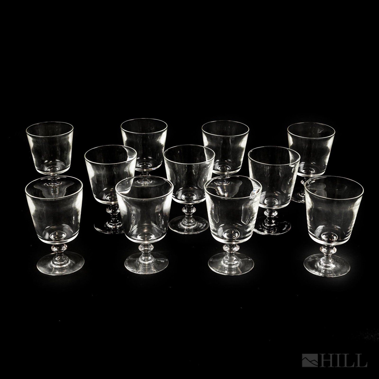 11 Steuben Art Glass Crystal Water Goblet Glasses: Lot of eleven crystal water goblets from Steuben. Features a large body with short stem. Measures 5 3/4 in. x 3 3/4 in. Comes in original box. Signed on base. Good overall condition with no damage to 