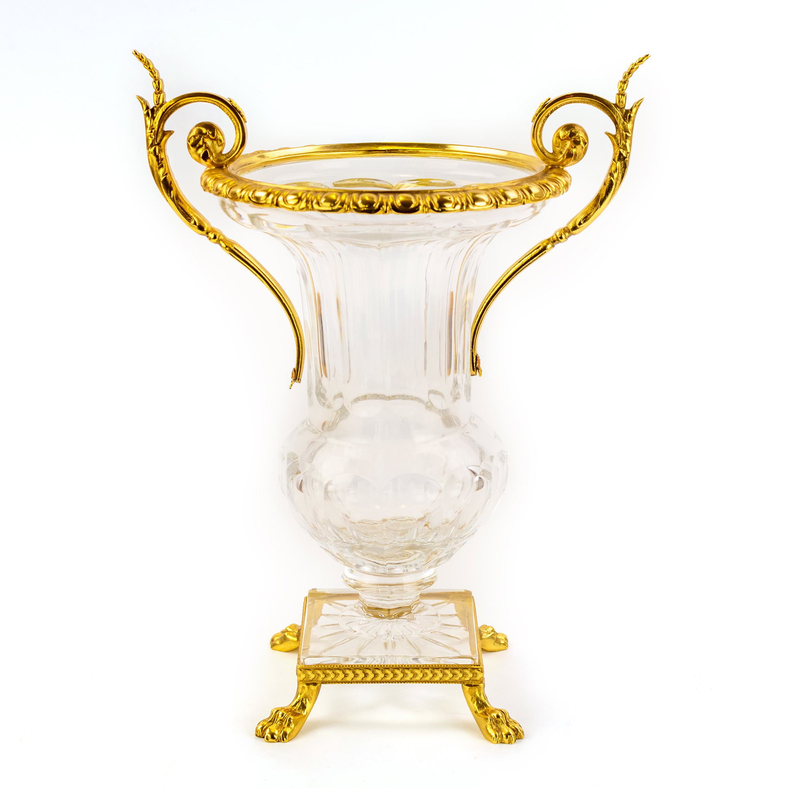 Continental Gold Gilt Ormolu Cut Crystal Urn Vase: Fine quality crystal vase with ormolu mounts. Clear glass in a classic urn shape. Lion paw footed base with ornate acanthus scroll double handle mounts. Polished bronze with a gold gilt finish. Overal