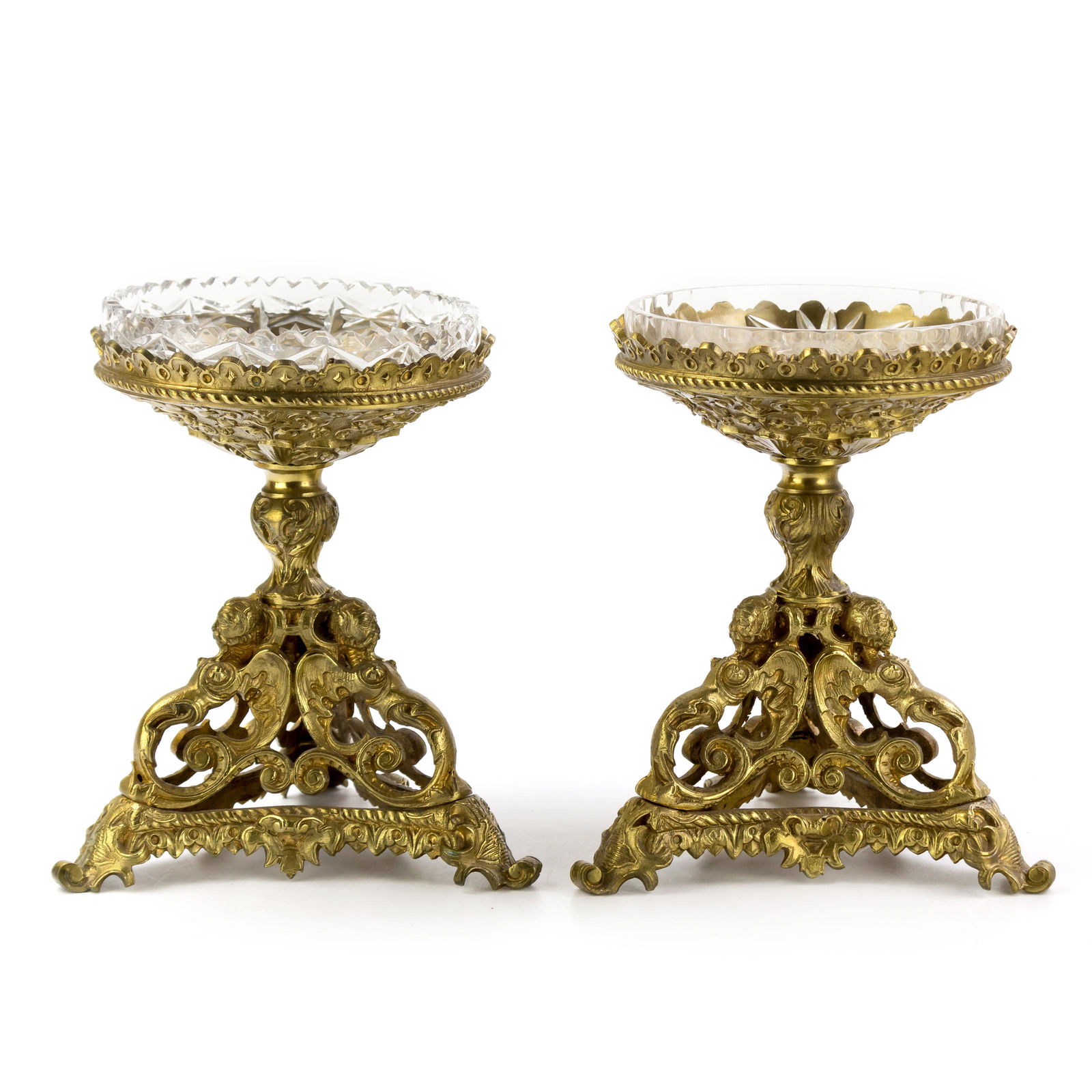Pair of Elegant Brass & Crystal Candy Dish Compote: An elegant pair of cut crystal candy dishes presented on ornate brass pedestal stands featuring winged mermaid figures. Cut crystal designs do not match. Measures 8 1/2 in. x 6 in. x 6 in. Good condit