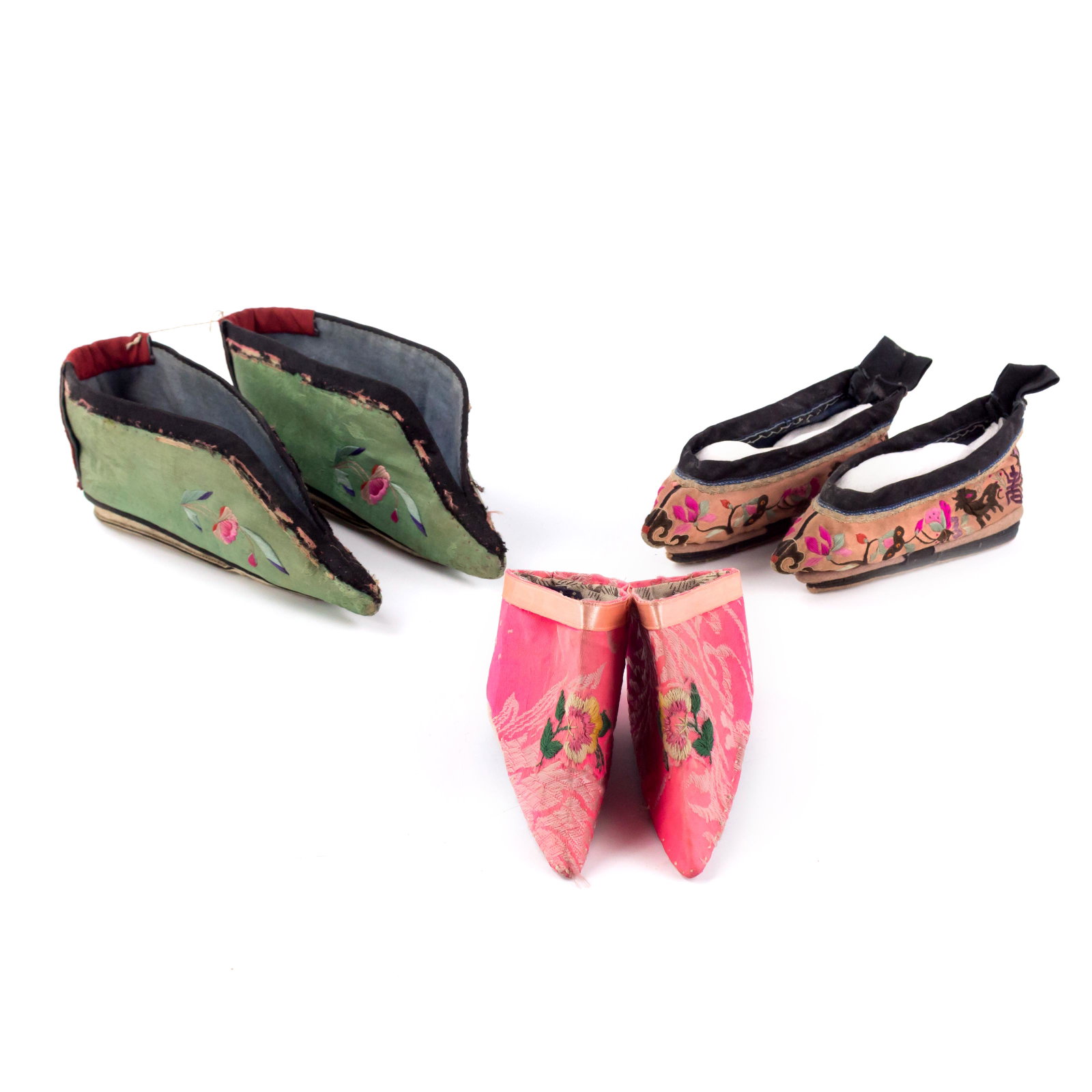 3 Pairs Chinese Republic Lotus Slippers Silk Shoes: Three pairs of early 20th Century Chinese shoes, decorated with silk, embroidered flora and allegorical animals, including stylized Guardian Lion Foo Dogs. The largest pair measures 3 in. x 7 1/2 in. 