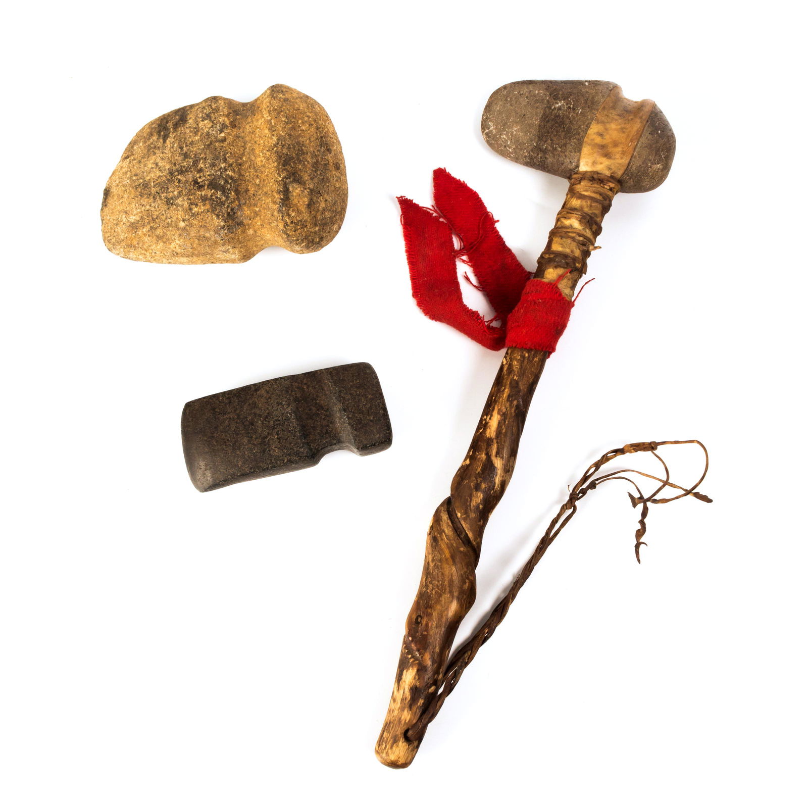 Archaic Primitive Hatchet & Pair of Stone Ax Heads: Group of three archaic tools, including primitive hatchet and two carved stone ax heads. Hatchet with attached stone head in natural material, measures 16 in.; ax heads measure 5 in. to 6 in. Good ove