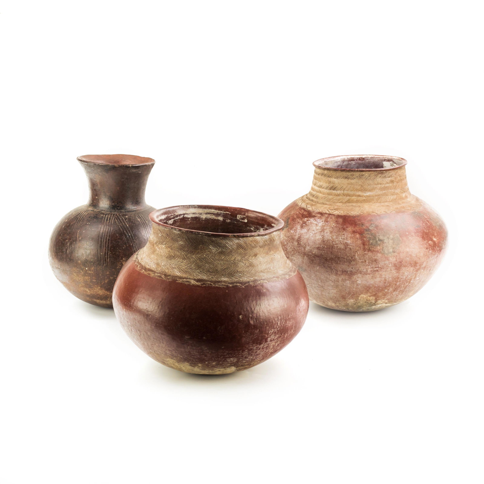 3 African Ceramic Clay Pottery Canister Pot Vessel: A collection of three large African clay jugs. Includes: dark jug with vertical line body design, measures 12 1/2 in. x 11 in.; squat red tone clay jug with fine line trim design around neck, measures