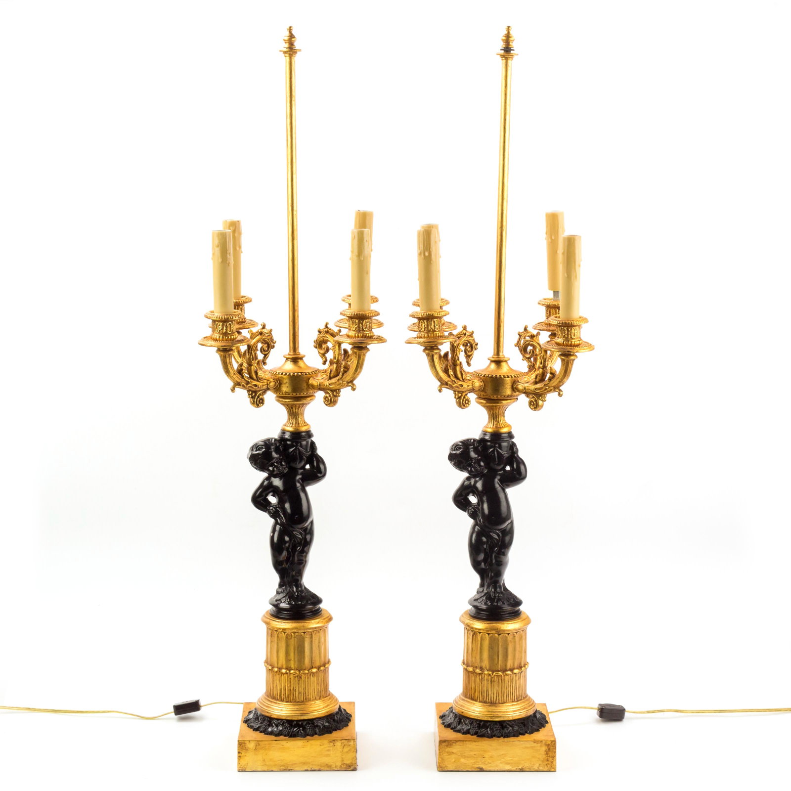 2 Ormolu Gilt Bronze Cherub Putto Candelabra Lamps: A striking pair of Ormolu gilded bronze four arm candelabra lamps produced in late French Empire style, with black lacquer cherub support bases. Decorated with black lacquered Art Nouveau flora beneat
