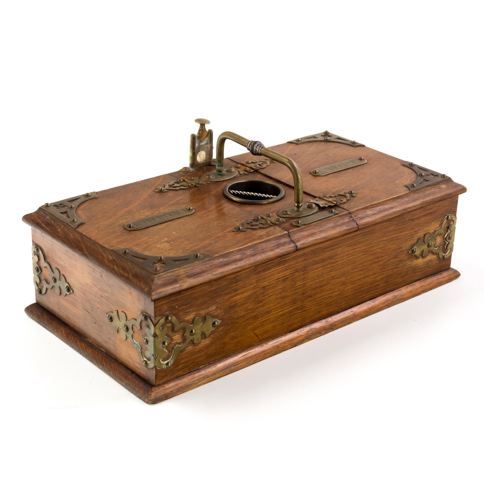 Antique Oak And Brass Cigar Cigarette Smoking Box: Antique oak and brass smoking box with two top hinged openings and brass “Cigars” and “Cigarettes” plaques. There is a blank brass shield on side of box, brass handle at top with cigar/cigaret