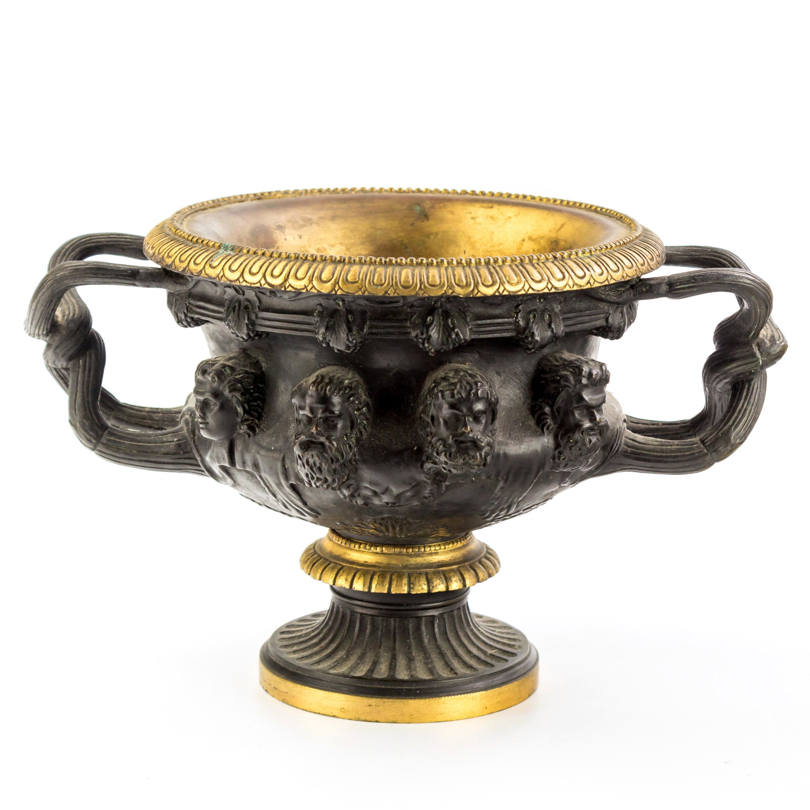 Bronze And Brass 6" Warwick Model Greek Face Vase: Antique Bronze & Brass continental urn after Warwick vase. Features classical ornament design of multiple Greek faces and reed entwined twin handles. Measures 6 1/2 in. x 10 in. x 7 in. Good condition