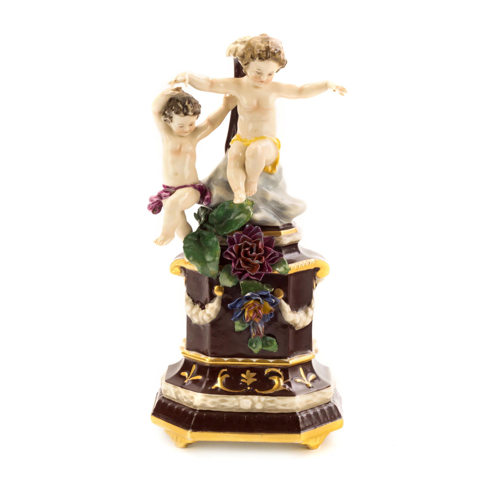 Capodimonte Porcelain Flower and Putti Figurine: Capodimonte hand painted porcelain figure depicting a pedestal with flowers and putti. Signed on underside with blue crown and "N". Figure approximately 10 in. x 4 1/2 in. x 4 in. Good condition, with