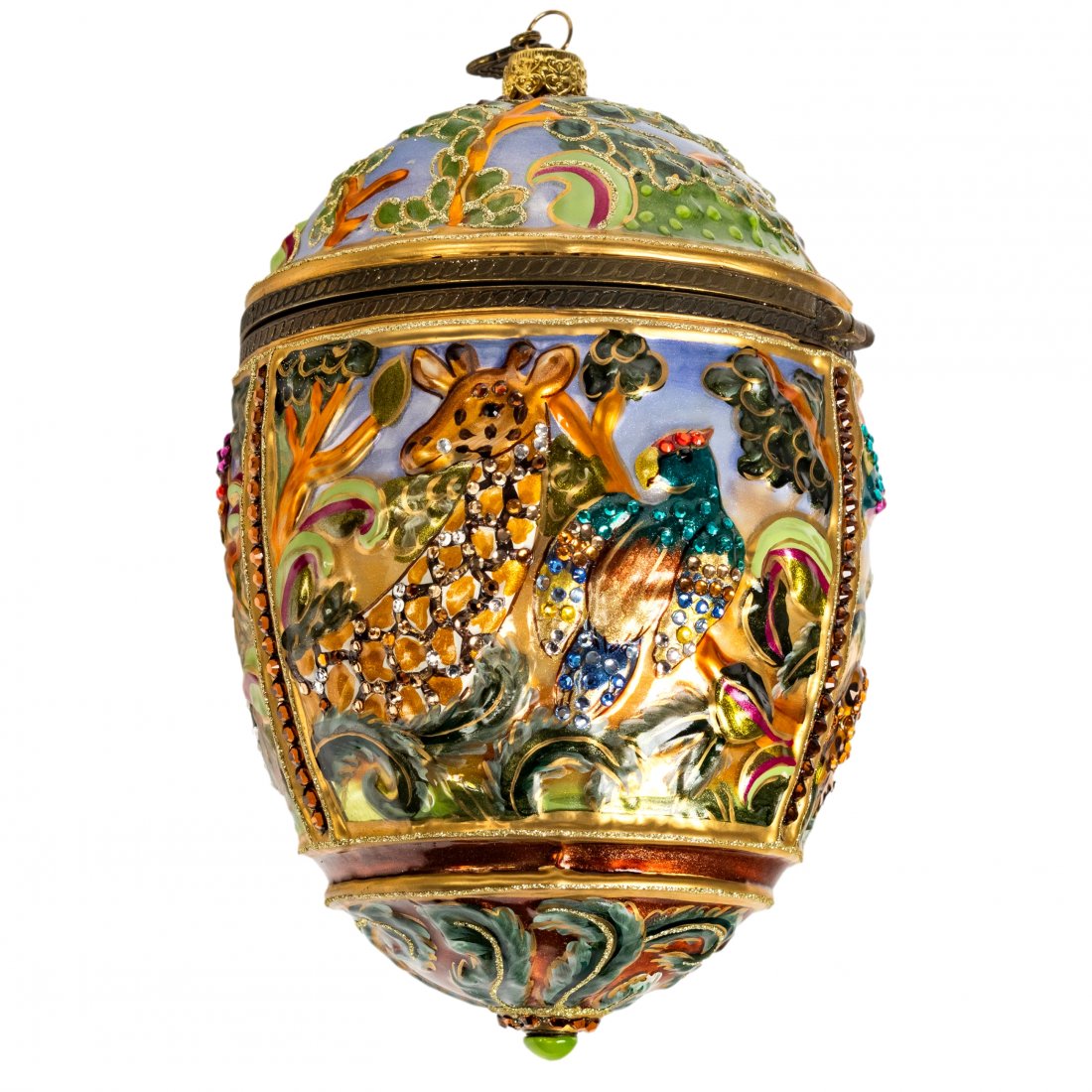 Jay Strongwater Jungle Egg Lidded Holiday Ornament: Jay Strongwater (American). Mouth blown glass egg ornament with encircling high relief scenes of jungle wildlife including a zebra, toucan, giraffe, parrot, leopard or cheetah, and elephant. Hand deco